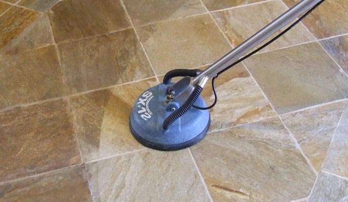 Maggy Maid professional tile and grout cleaning service using a rotary floor scrubber machine on stone tile flooring